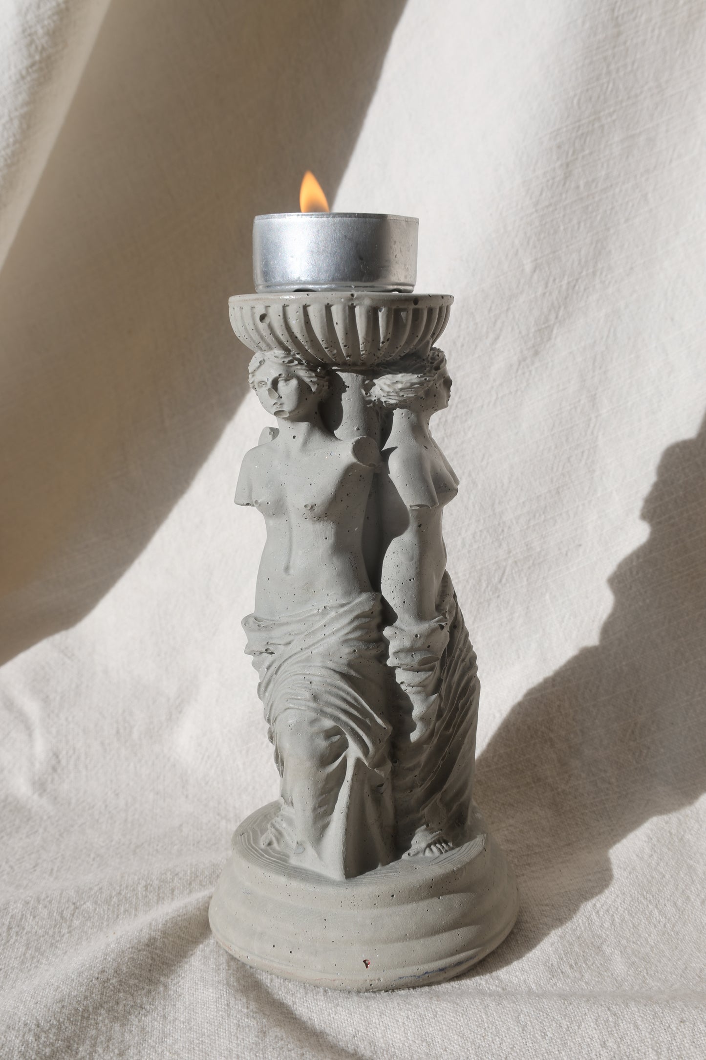 Concrete candle holder with three Venus by Lily Glow Decor figures and a tealight candle