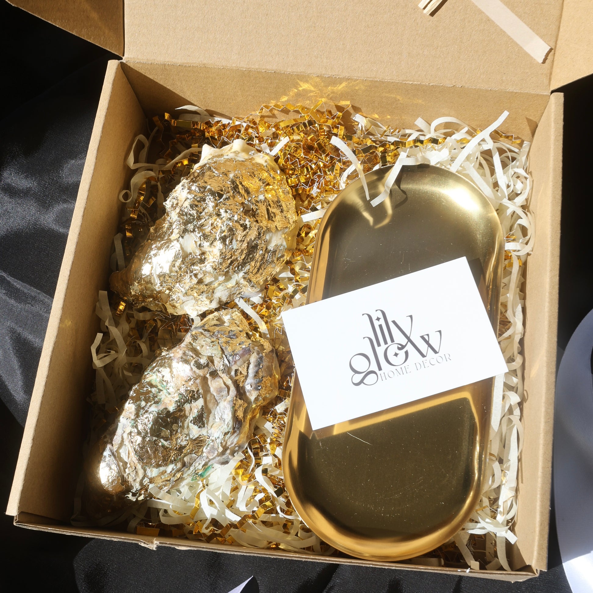 Gift box with two gold-covered seashell candles and a golden candleholder from Lily Glow Decor