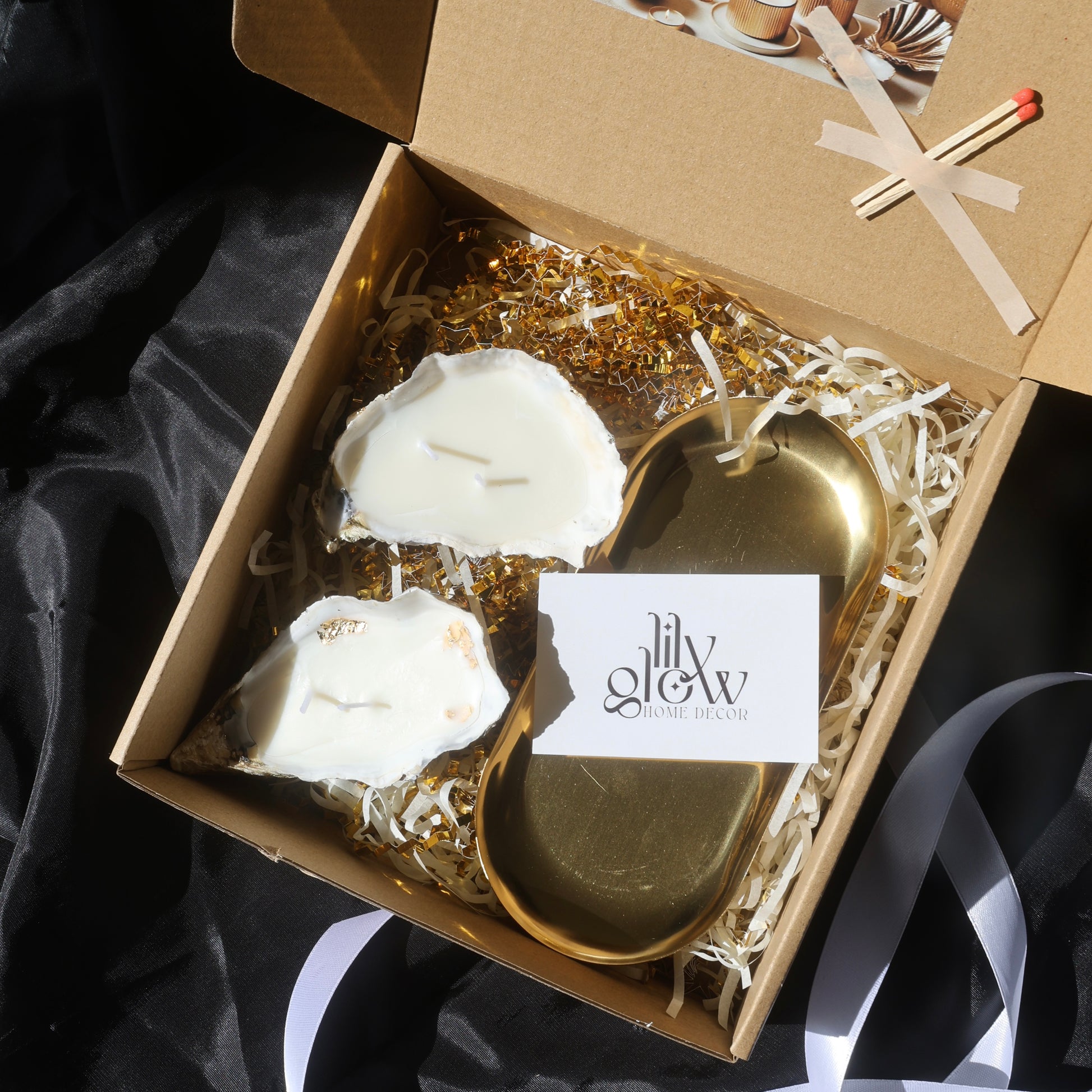 Gift box with two gold-covered seashell candles and a golden candleholder from Lily Glow Decor