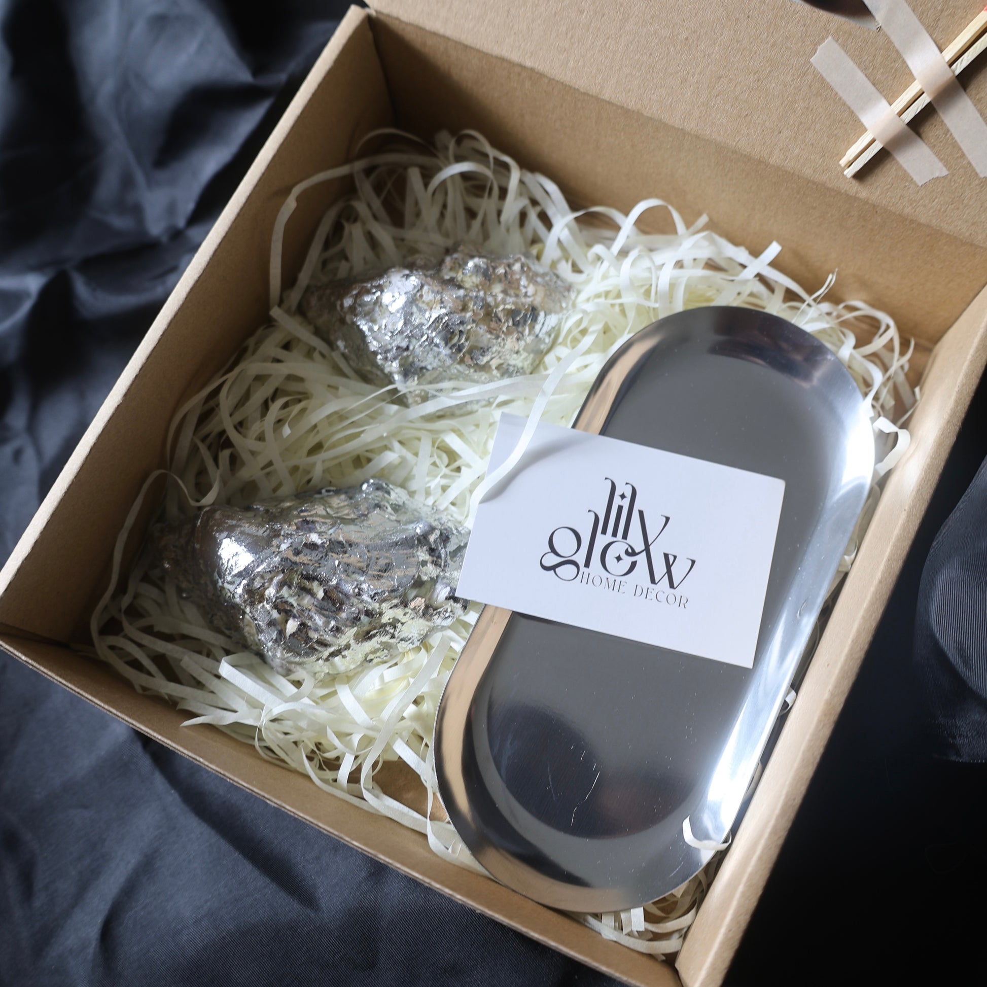 Two seashell candles with silver candleholder candleholder inside a gift box by Lily Glow Decor