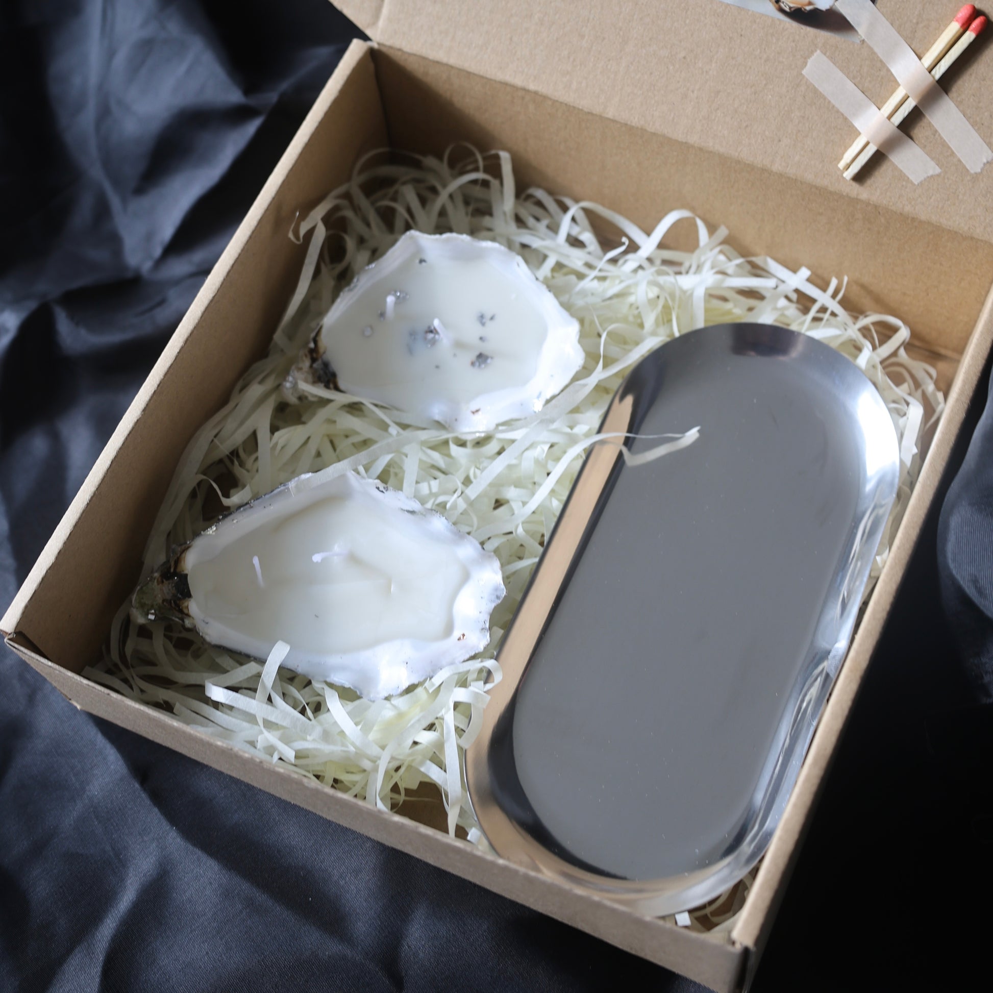 Two seashell candles with silver candleholder candleholder inside a gift box by Lily Glow Decor