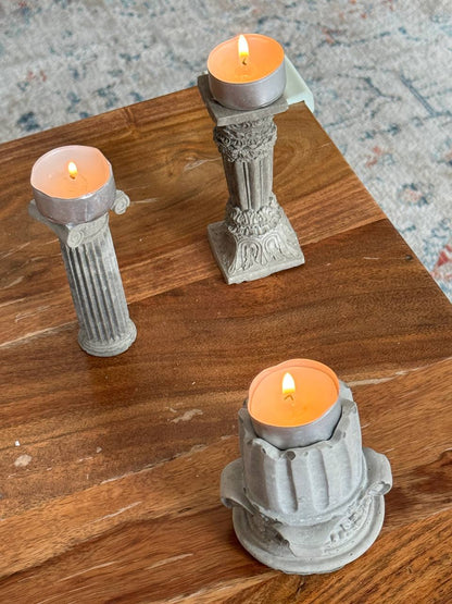 three architectural-style candle holders with tealights, featuring an Ionic column in the background by Lily Glow Decor