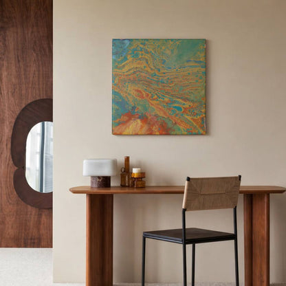 Abstract painting in 30x30 cm format with fluid patterns in blue, green, orange and beige tones, displayed against soft beige fabric by Lily Glow Decor