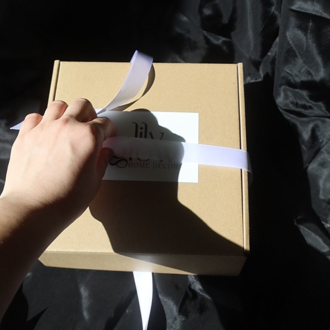 Gift box with two gold-covered seashell candles and a golden candleholder from Lily Glow Decor