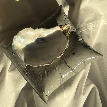 Concrete pillow-shaped candleholder with a glossy finish for displaying a seashell candle by Lily Glow Decor