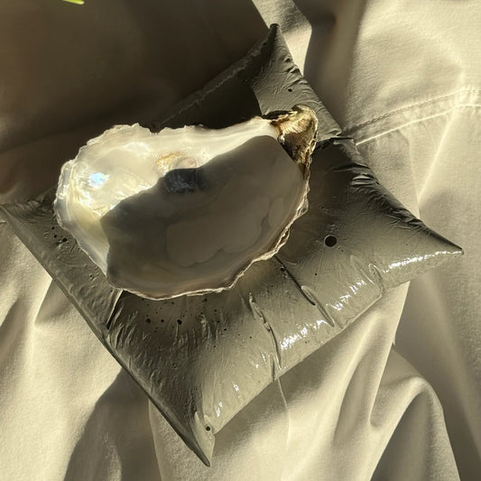 Concrete pillow-shaped candleholder with a glossy finish for displaying a seashell candle by Lily Glow Decor